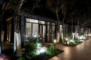Moderne Außenbeleuchtung mit LED-Strahlern an einem Gartenweg vor einem beleuchteten Gebäude